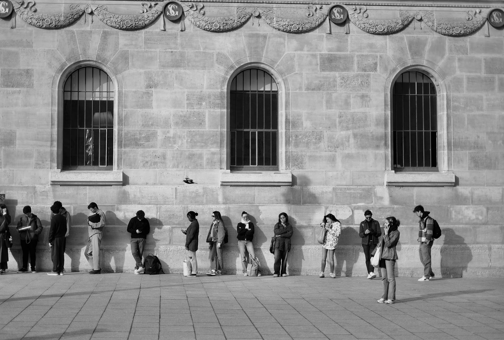 People Waiting and Standing by Wall