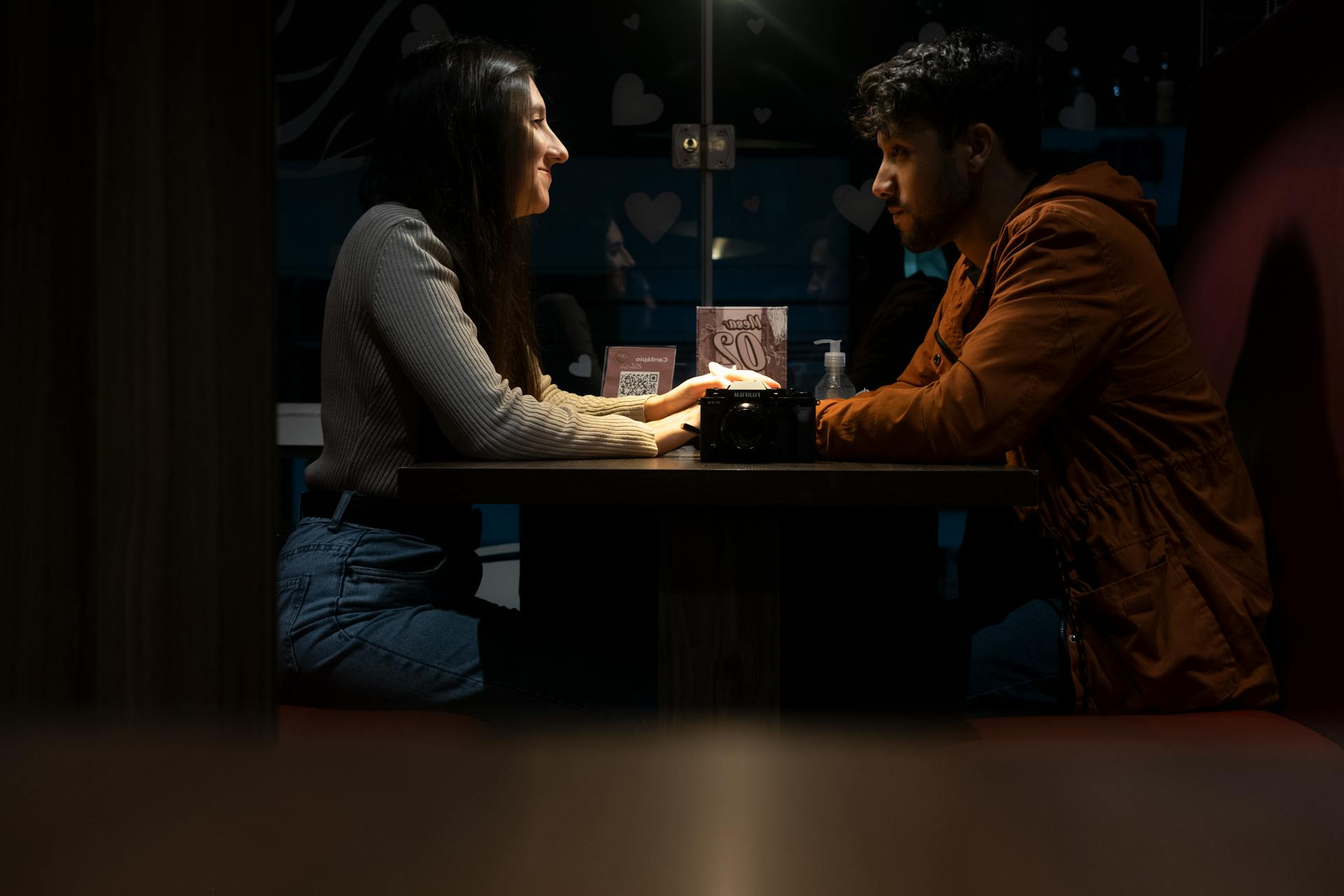 Couple Sitting Near the Table while Looking at Each Other