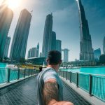Man in Grey T-shirt Crossing a Foot Bridge in Dubai
