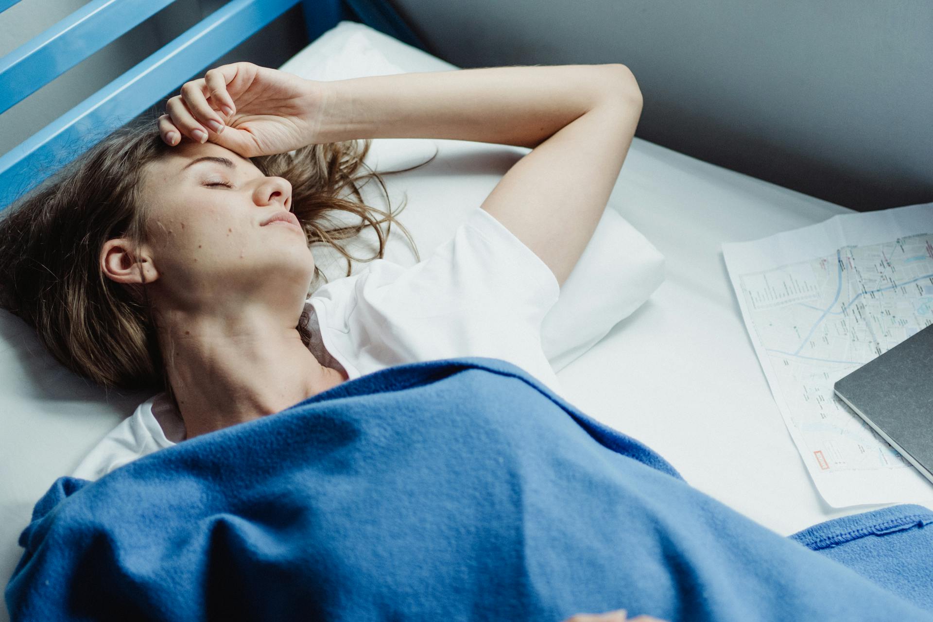 Woman Lying Down on a Bunk Bed under Blue Blanket