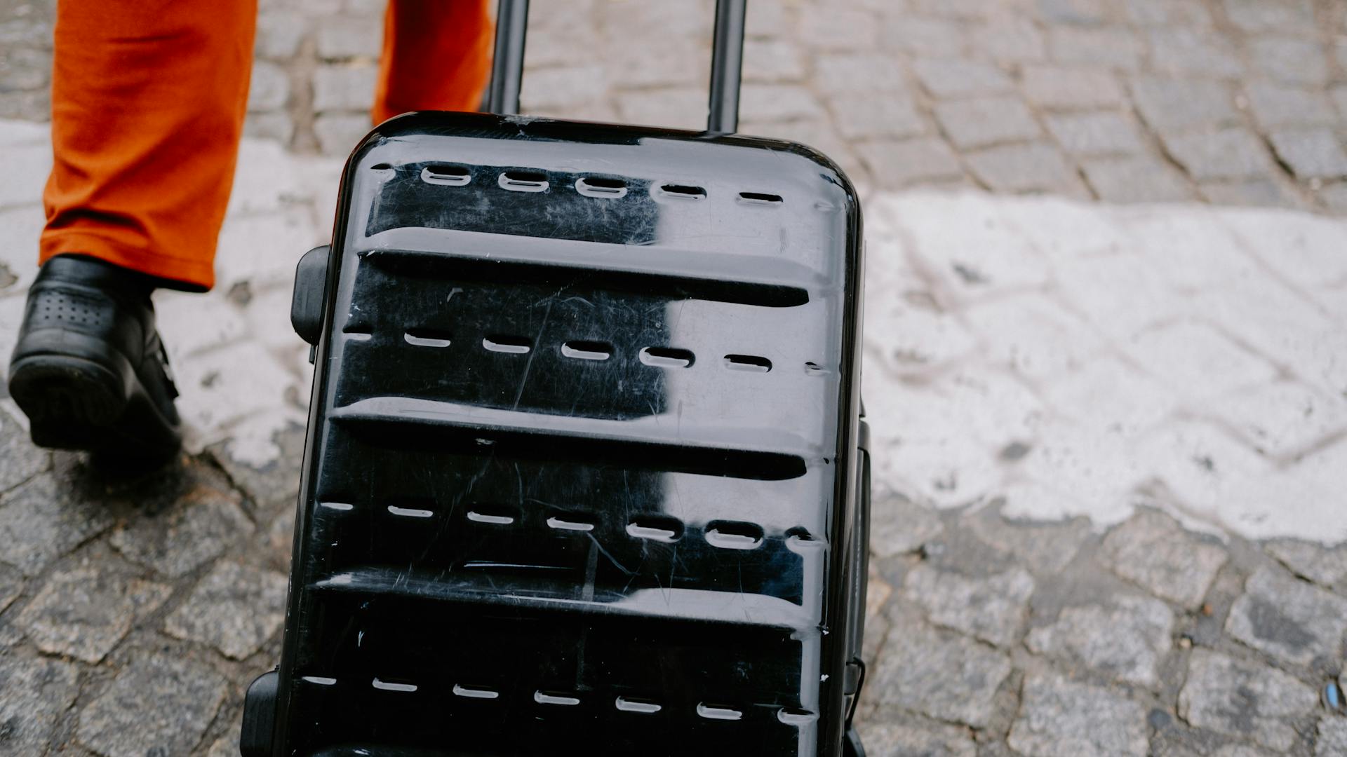 Person Pulling a Black Trolley Bag