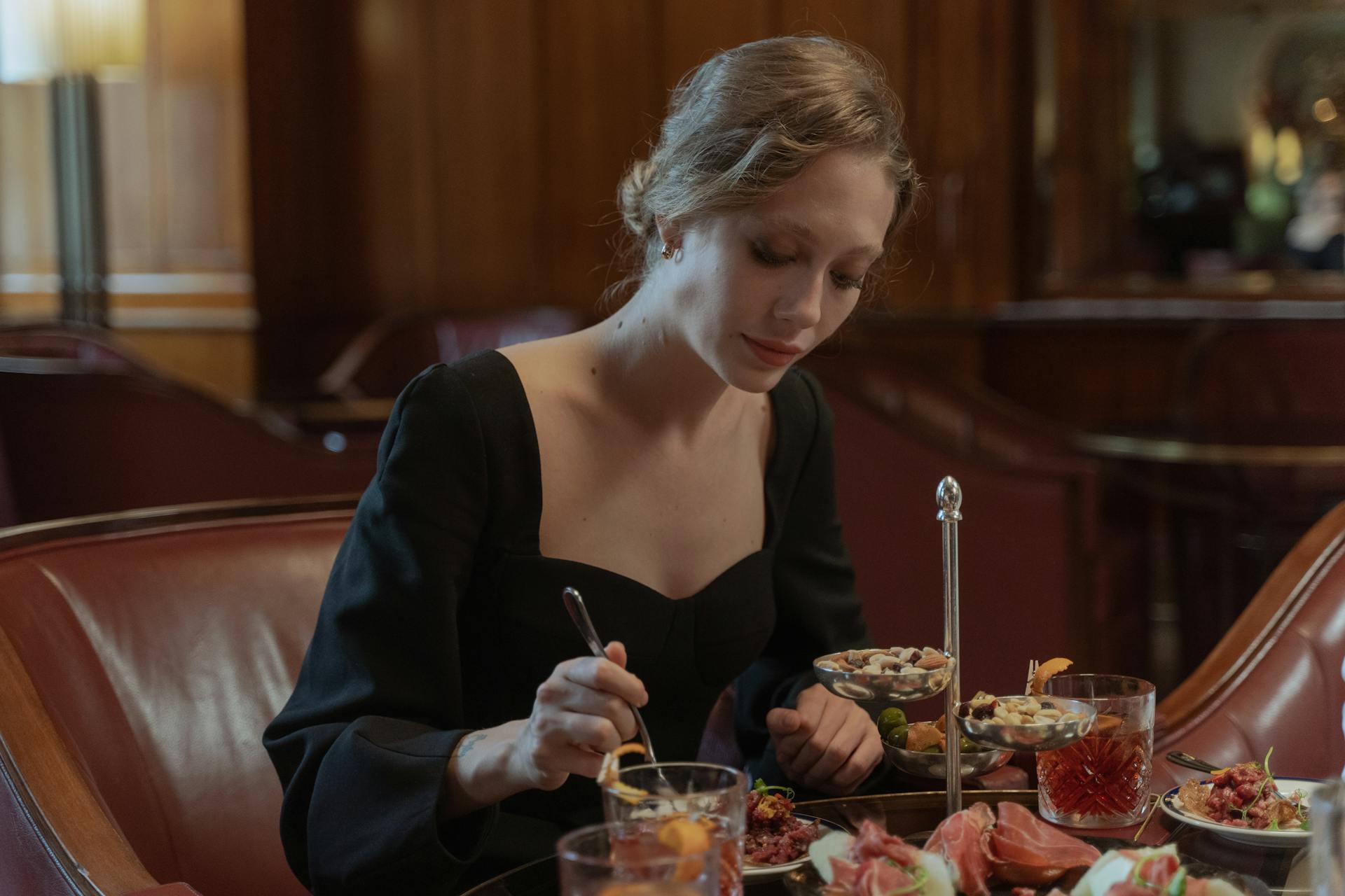 A Woman Wearing a Black Dress having Dinner
