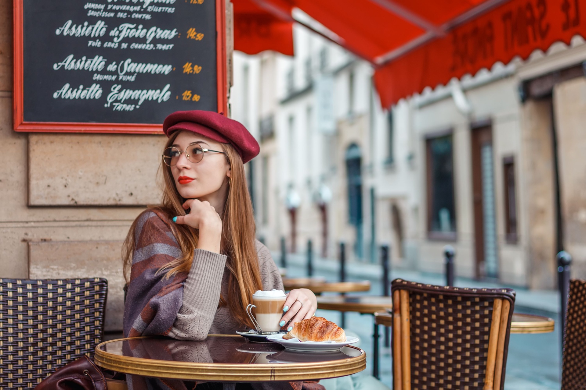 Beautiful girl drinks coffee in the morning in a cafe in paris
