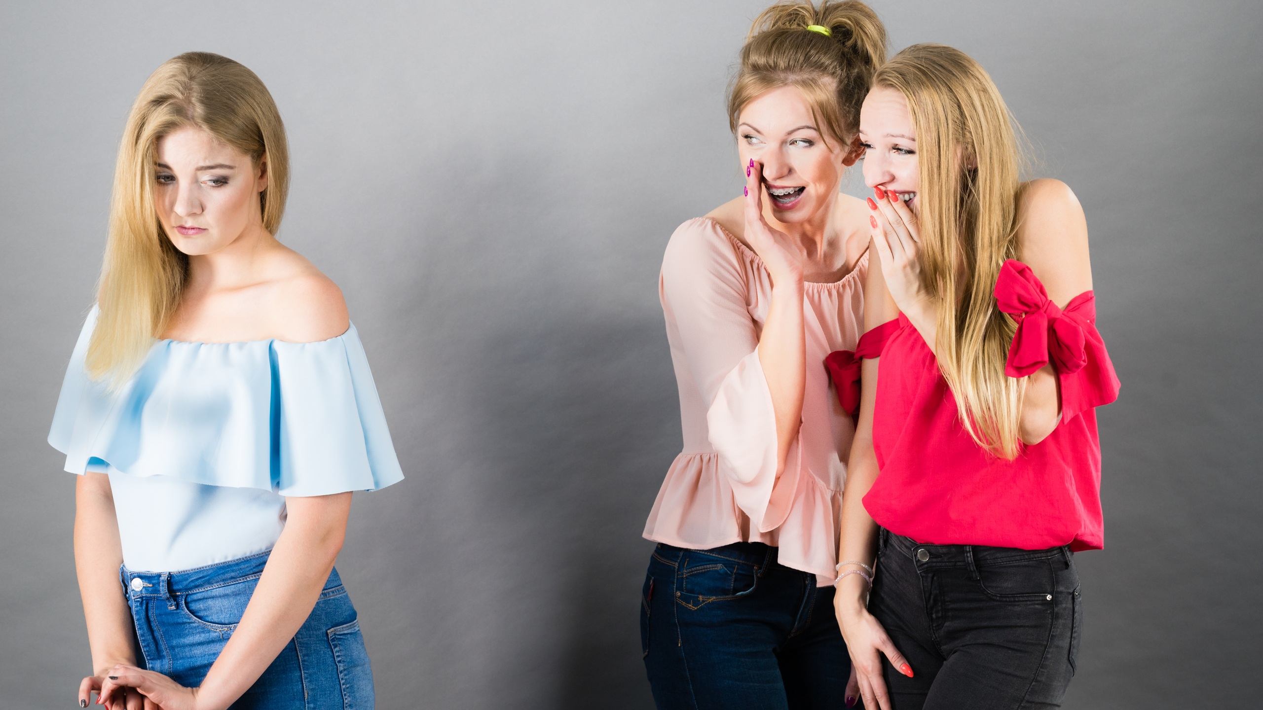 Woman being bullied by two female friends gossiping about her. Friendship rivaly and envy problems.