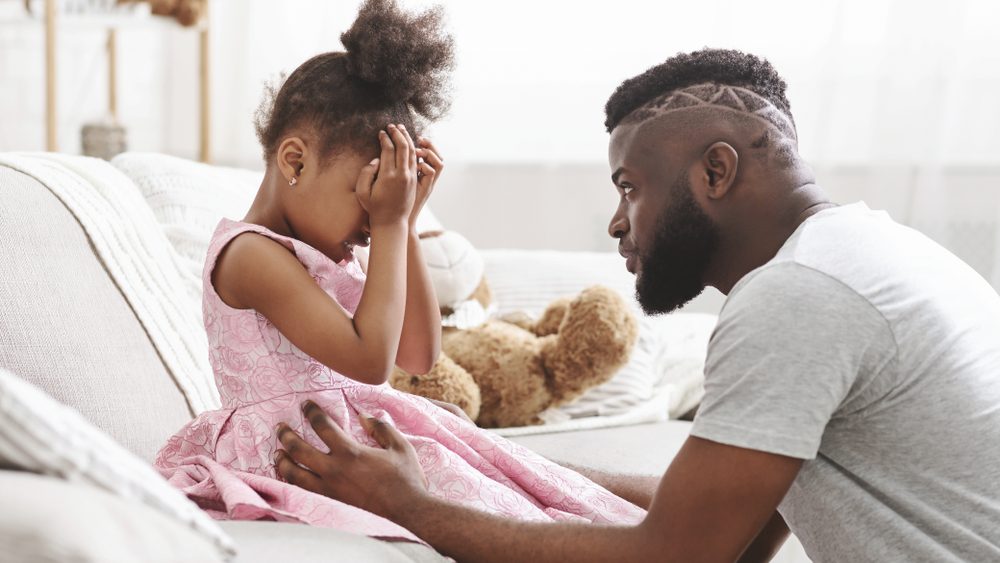 Loving african american dad comforting crying daughter, supporting little stressed girl in tears, giving empathy protection at home
