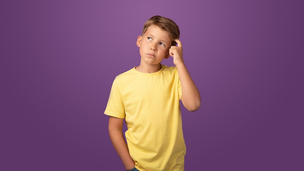 Thoughtful preteen kid boy standing with puzzled serious expression, making choise thinking against purple background. Studio shot