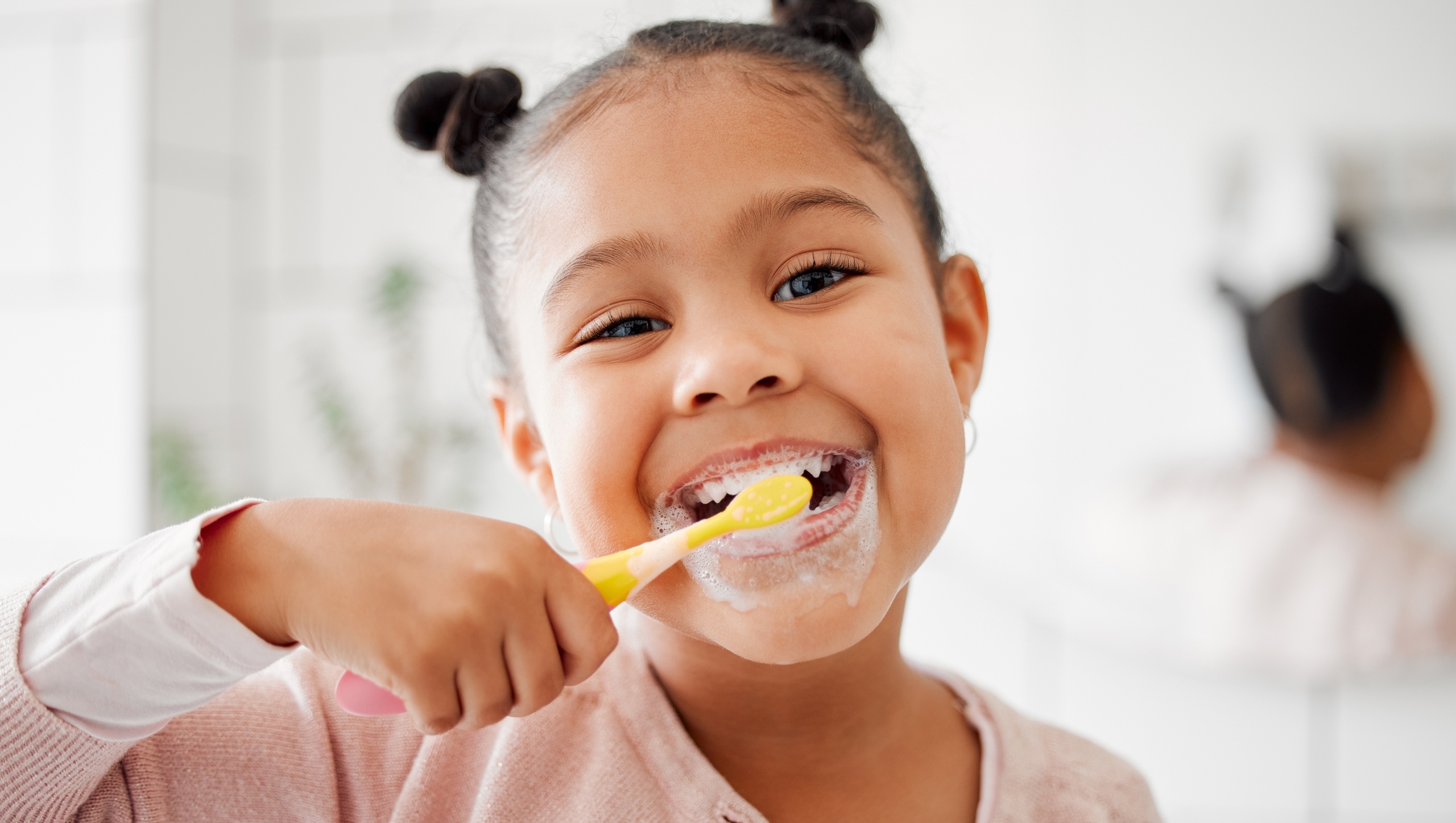 Toothbrush, brushing teeth and face of a child in a home bathroom for dental health and wellness. Smile portrait of african girl kid cleaning mouth with a brush for morning routine and oral self care