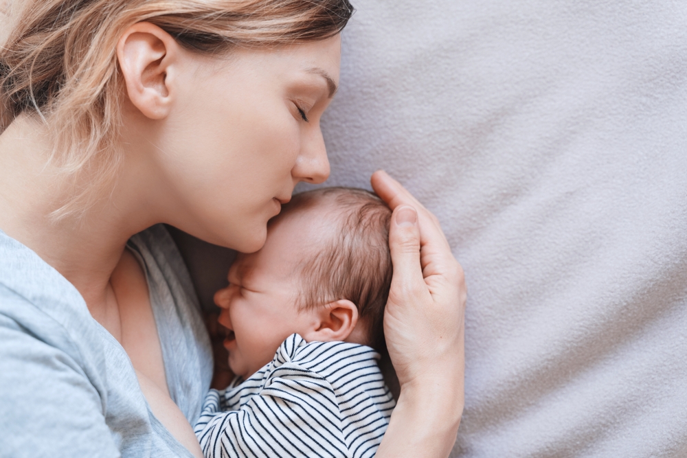 Mother and baby. Loving mom spending time with her little 2 weeks old child at home. Image of bonding mother and baby, healthy physical and mental development of child, happy maternity and family.