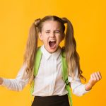 Crazy Angry Schoolgirl Shouting Furiously Over Yellow Studio Background. Free Space