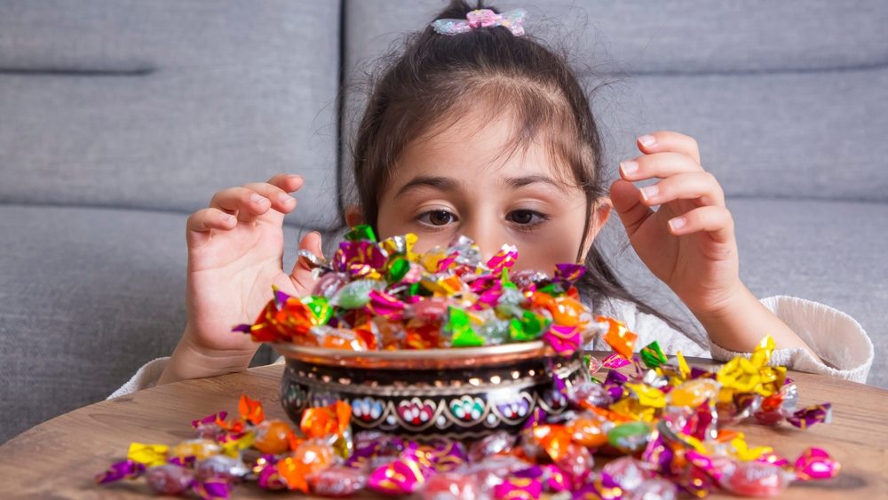 Happy girls with holiday candies in their hands. Turkish Ramadan holiday is also known as the candy holiday. Holiday candy concept.