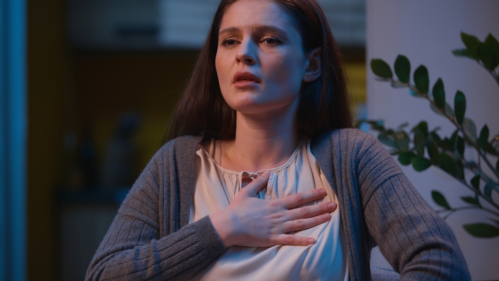 Stressed woman heart attack pain in chest sick Caucasian girl at night home evening health problem ache emergency medicine help heartache hurt in breast symptom pressure cardio unwell female scared