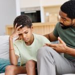 Portrait of a teenage boy son talking to his father at home. Sharing secrets and problems, support and parenthood concept