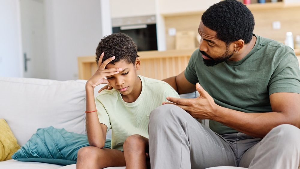 Portrait of a teenage boy son talking to his father at home. Sharing secrets and problems, support and parenthood concept