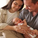 Happy parents with their newborn baby at home, closeup