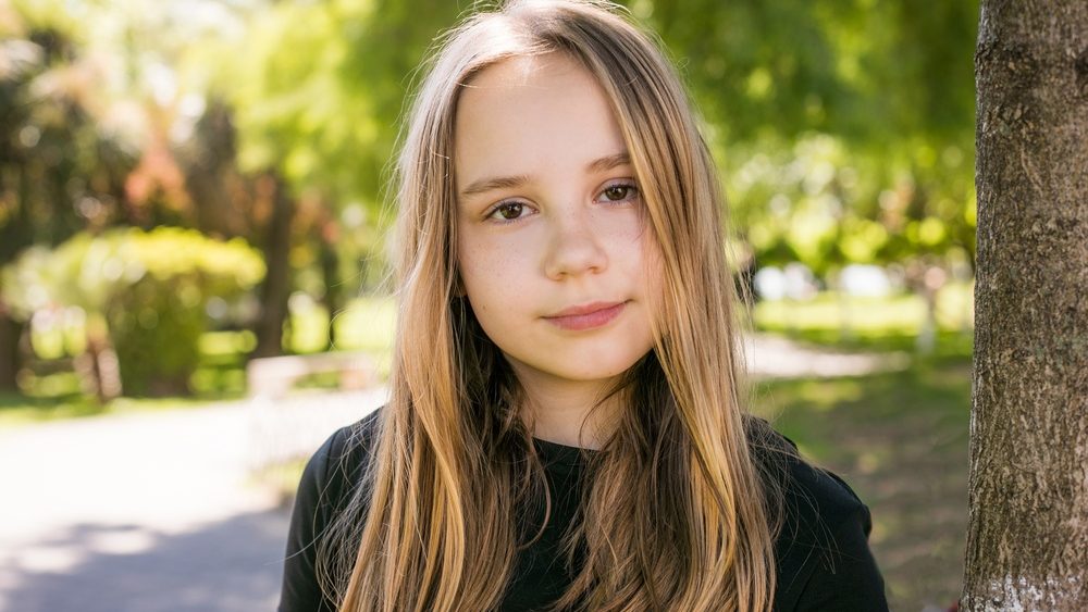 Beautiful child looking at camera outdoors. Beautiful girl portrait