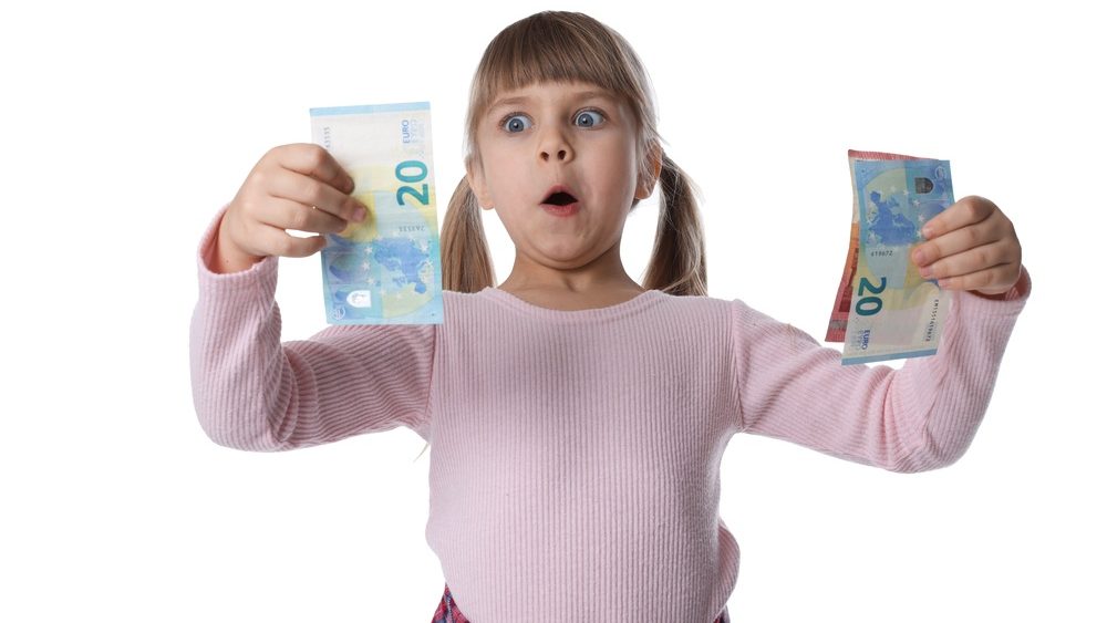 Pocket money. Surprised little girl with euro banknotes on white background