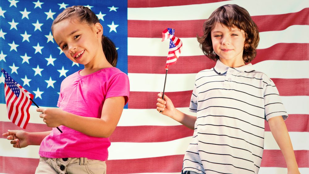 Children with american flags against rippled us flag