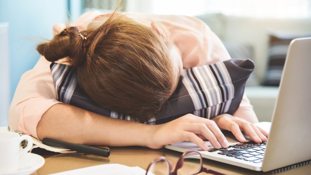Exhausted, Tired Asian Businesswoman sleeping on desk while working. Overtime and overwork concept. Laptop computer.
