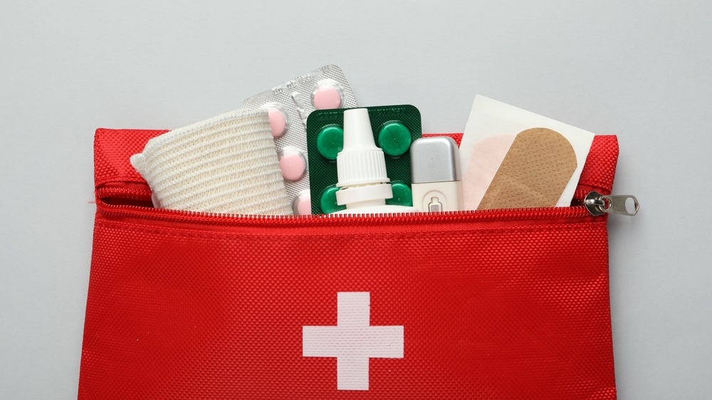 First aid kit on gray background, top view