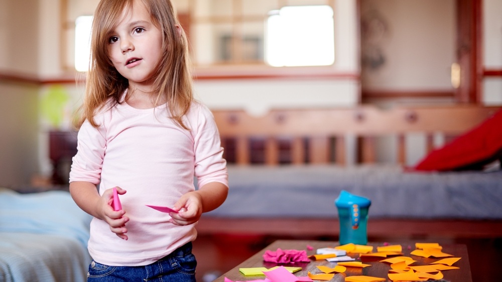 Home, creative and girl child with mess for remote learning, education and writing skills. School, playing or artistic female kid with sticky notes for planning, drawing or development for project