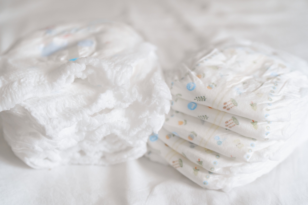 A pack of diapers on a white bed, stack of diapers. High quality photo