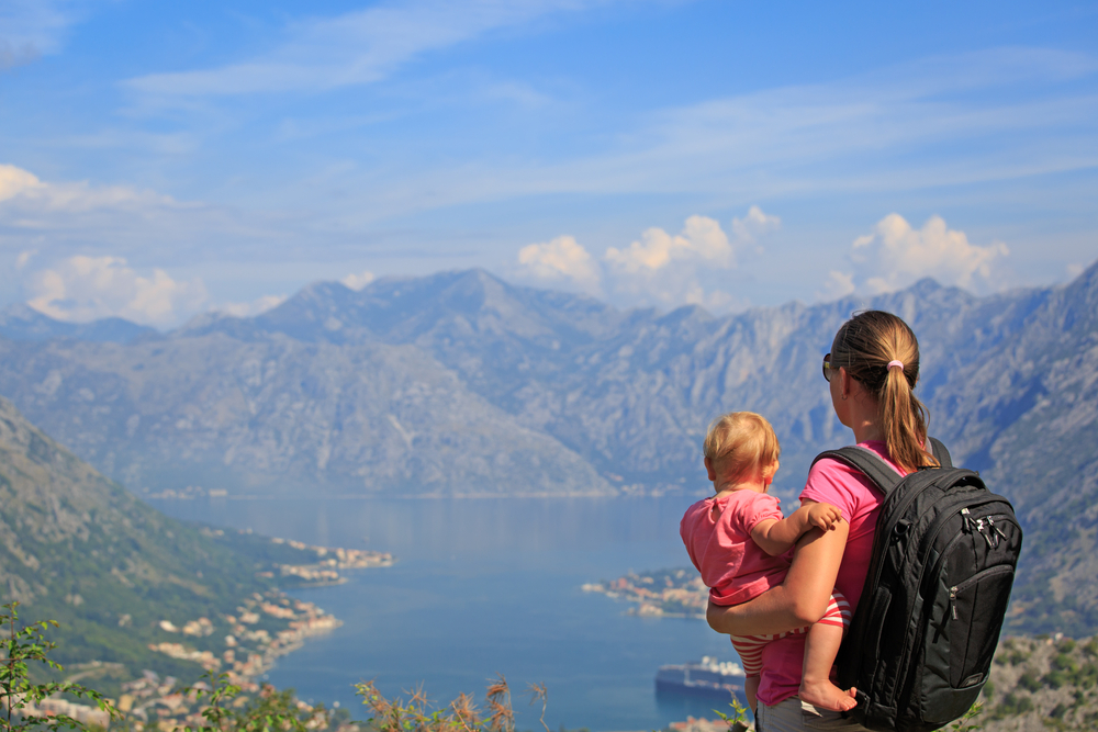 mother with little daughter looking at mountains on vacation