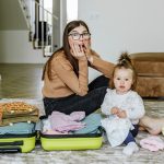 Vacation preparation. Woman is packing for vacation with baby. Mom is afraid to forget something