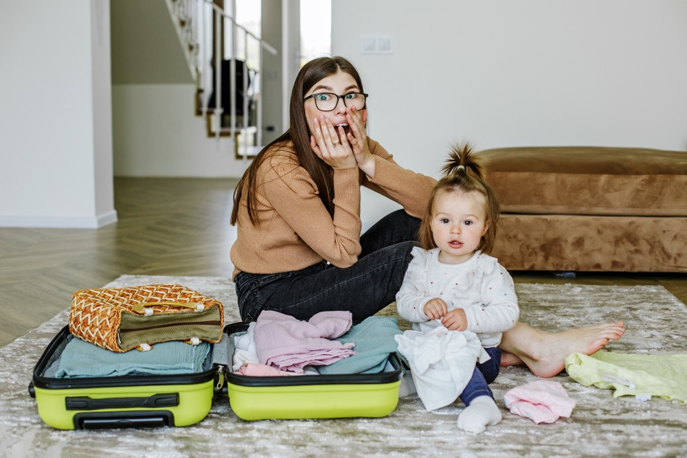 Vacation preparation. Woman is packing for vacation with baby. Mom is afraid to forget something