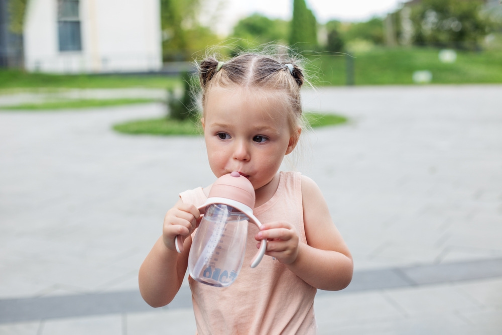 Toddler girl drinking water.Two year old. Leak proof bottle.